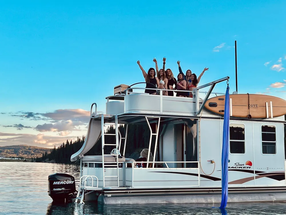 The boat from the water at sunset, guests along the top deck